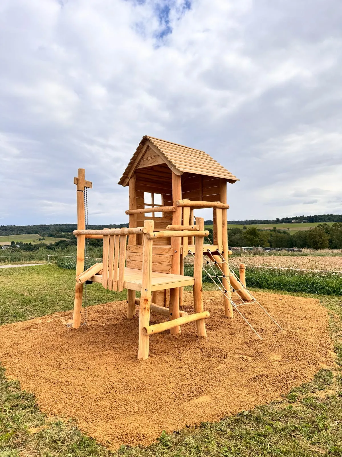 Robinie-Spielturm mit Holzdach und Kletterleiter, montiert von Moshrif Spielplatzbau in Stadtallendorf