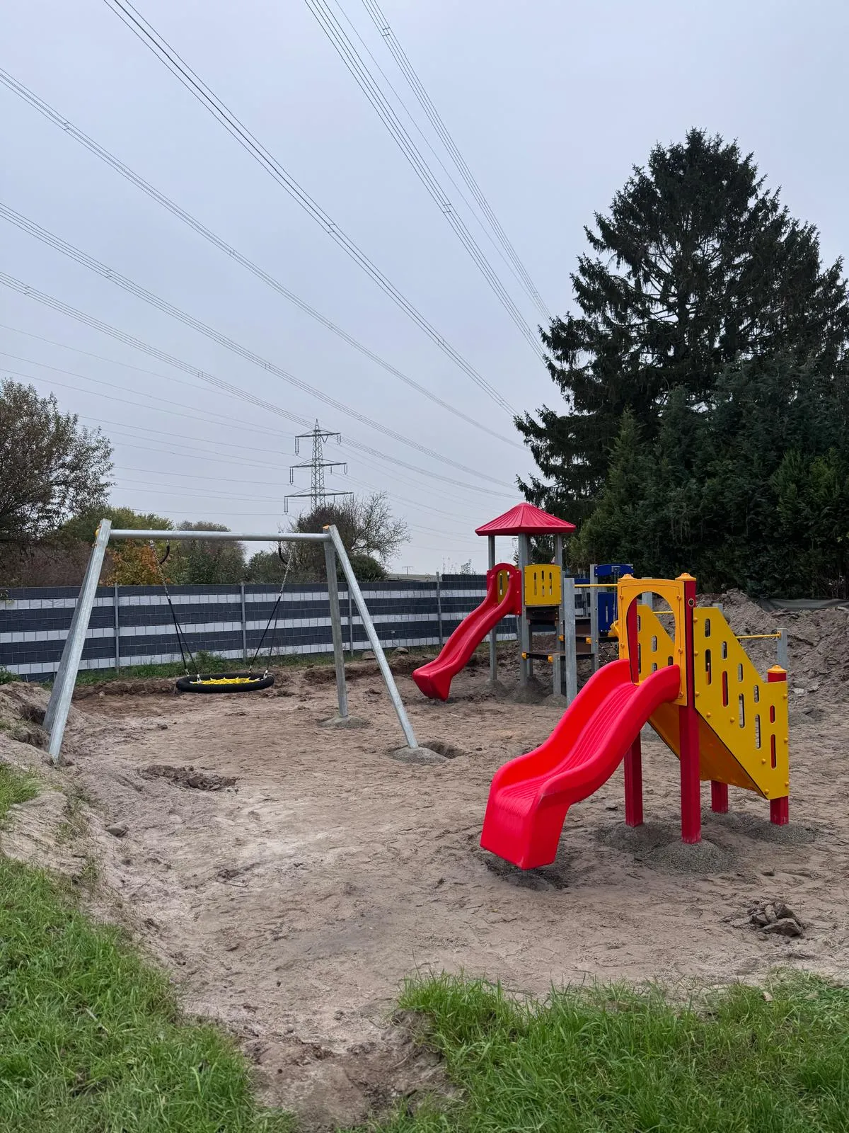 Spielhaus aus Robinie mit Kletterwand und Rutsche auf einem Kita-Spielplatz, montiert von Moshrif Spielplatzbau in Rheinböllen