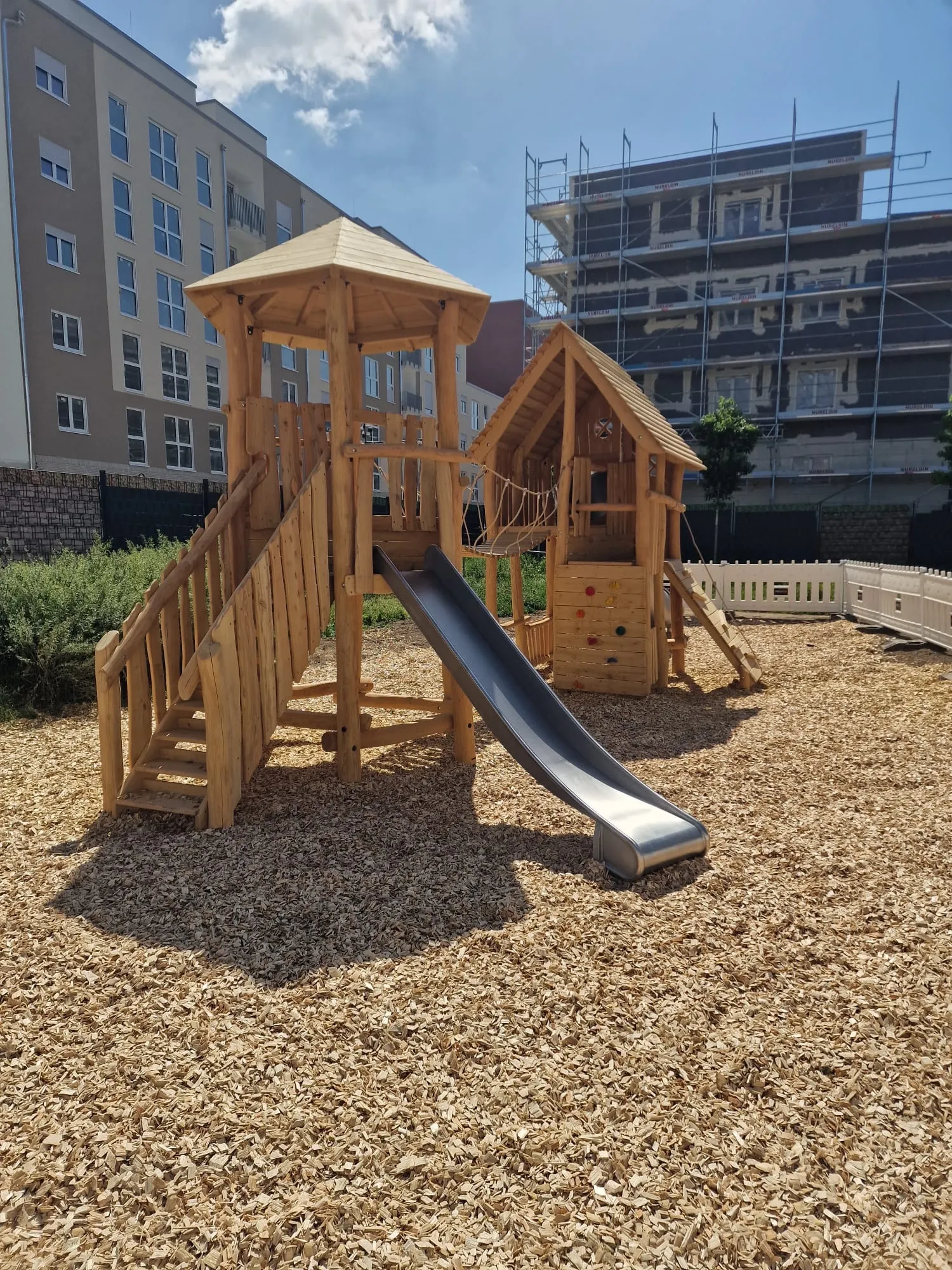 Spielturm aus Robinienholz mit Edelstahlrutsche, montiert von Moshrif Spielplatzbau in Frankfurt am Main