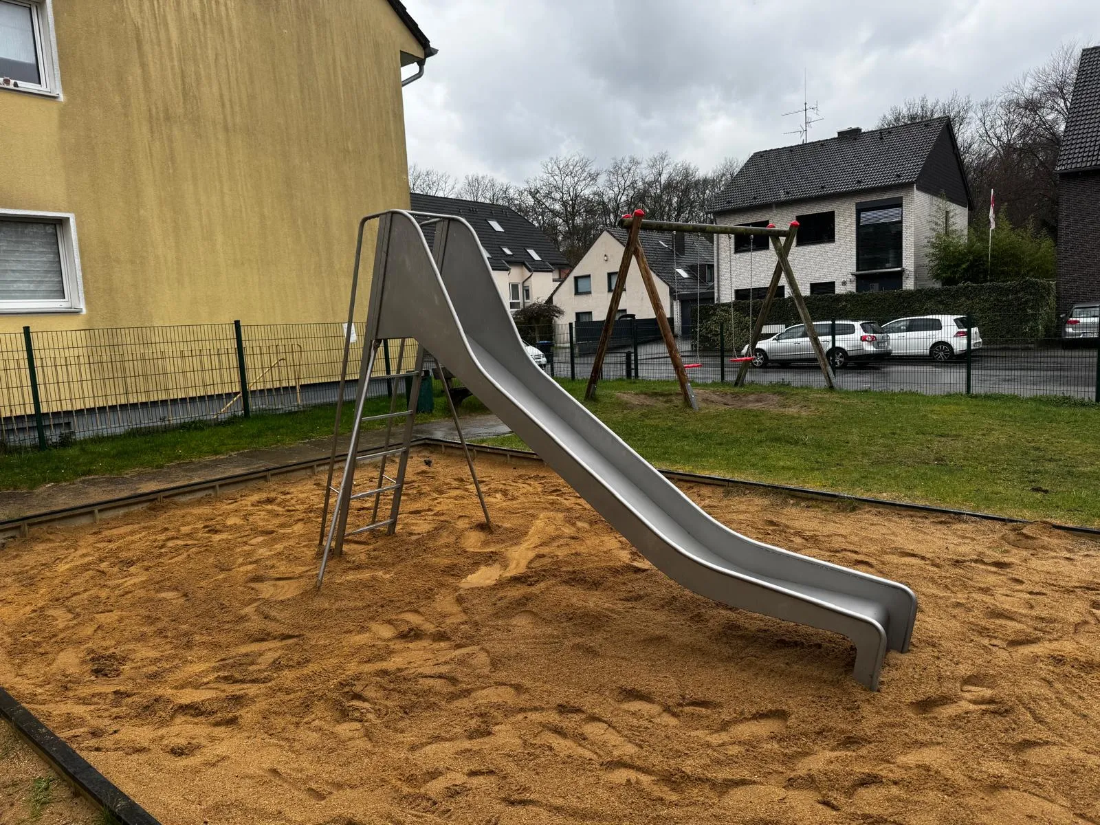 Lange Edelstahlrutsche mit Aufstiegsleiter im Sandbereich, montiert von Moshrif Spielplatzbau in Hamburg