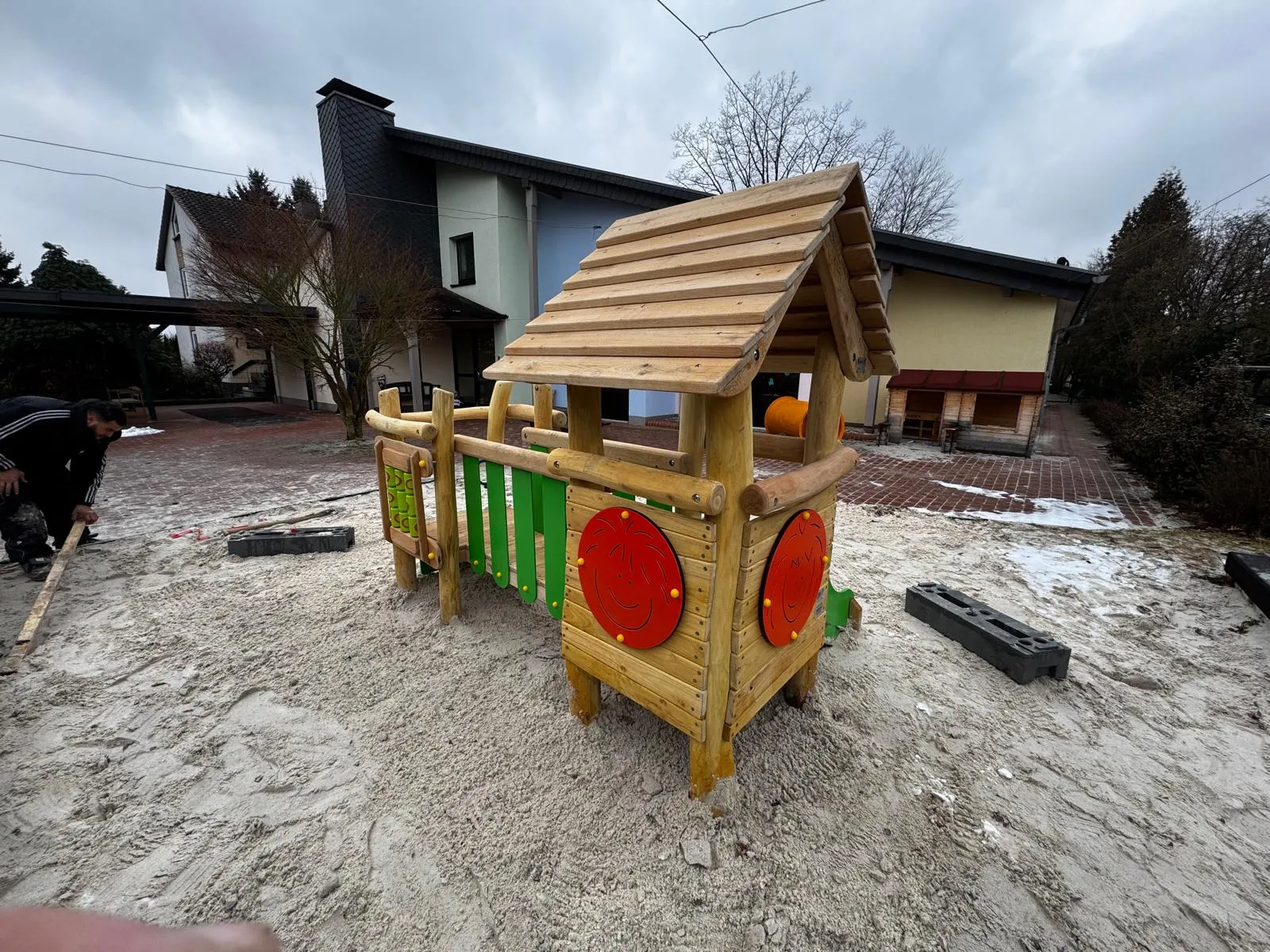 Robinie-Spielhaus mit grünen Stäben und roten Spielelementen, montiert von Moshrif Spielplatzbau in Erfurt